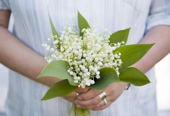woman with a bouquet of lilies of the valley