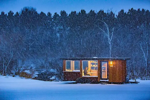Snowy exterior of wooden paneled tiny home