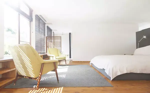 Armchairs, rug and bed in modern bedroom