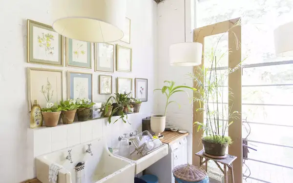 Wall hangings and lights over rustic kitchen sink