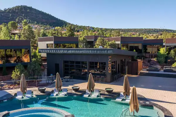 Aerial view of pool and lounge with cabin rooms behind at Ambiente in Sedona, Arizona