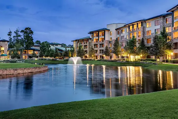 Lakeside view with fountain, multi-story resort buildings in a landscaped setting
