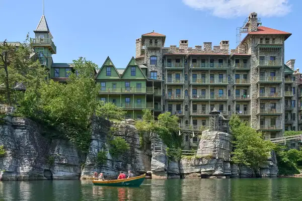 A resort building near a lake with a small boat in the water