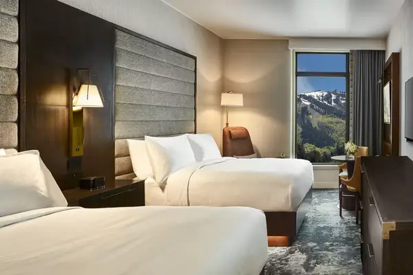 Hotel room with two beds and a view of mountains through the window