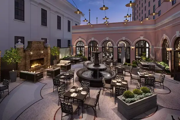 The Hotel Courtyard and Iron Rose Outdoor Seating at Mills House Charleston, Curio Collection by Hilton