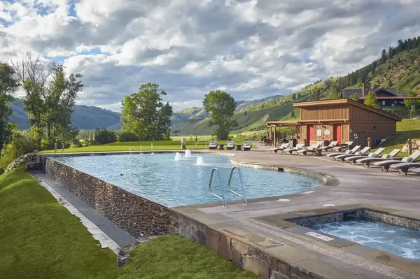 Outdoor pool with lounge chairs and scenic mountain surroundings