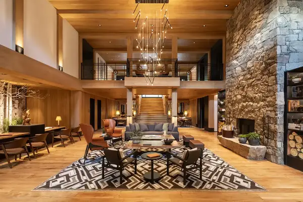 Large openconcept lodge lobby featuring a seating area a stone fireplace and a sophisticated ambiance