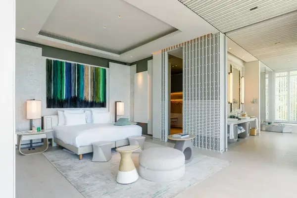 clean hotel room with white accessories and large sliding wall to bathroom