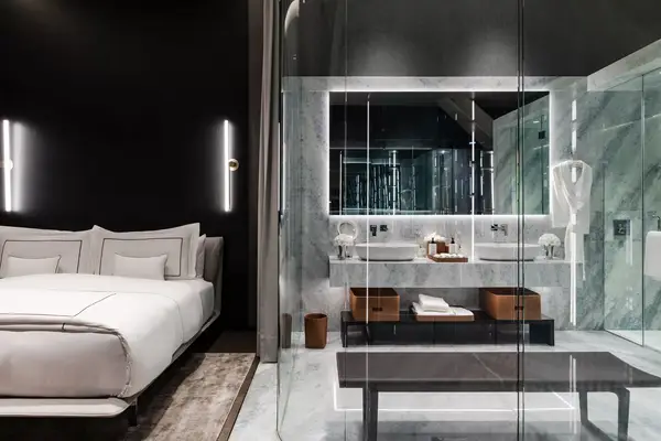 A hotel room with a glass bathroom