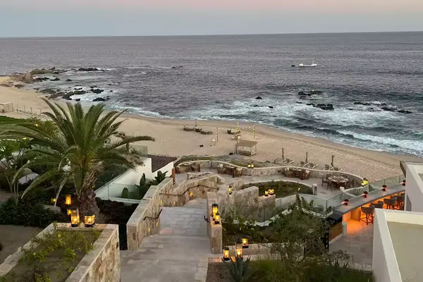 stone staircase leading down towards a beach at sunset