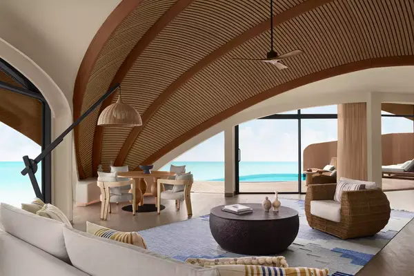 room with a curved ceiling with wooden bone structure with tall windows letting sunlight in