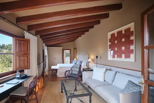 A guest room at a hotel in Spain with wooden beams on the ceiling