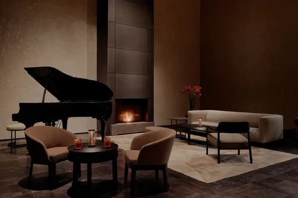 A cozy lounge with a piano chairs and a fireplace