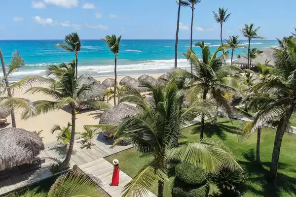 A woman in a red dress walking through Excellence Punta Cana