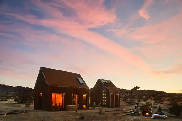 Exterior of cabin at sunset in the desert with a fire pit