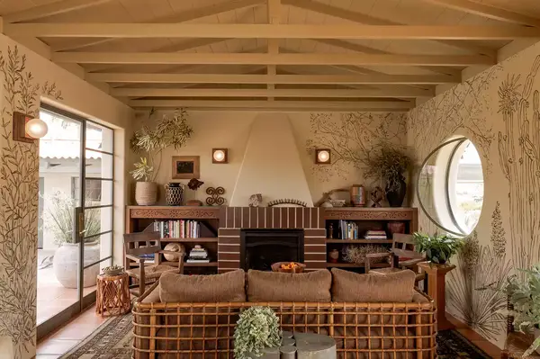 Living room with wood furniture and built-in bookshelves, decorative fireplace, and patterned wallpaper