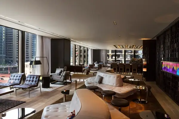 A spacious and modern lounge area with seating large windows and city view