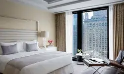 Luxury hotel room interior with bed floortoceiling windows and downtown city view