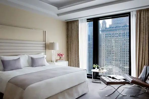 Luxury hotel room interior with bed floortoceiling windows and downtown city view