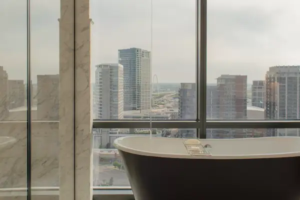 King room soaking tub with water coming in from the ceiling and sweeping views of Dallas