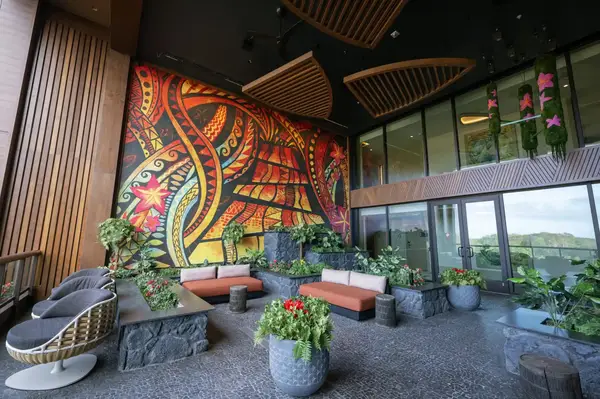 Lounge area with a vibrant Polynesianthemed mural behind seating