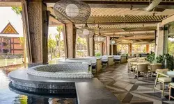 Outdoor seating area of a Polynesianthemed bar and grille near water with decor and furniture