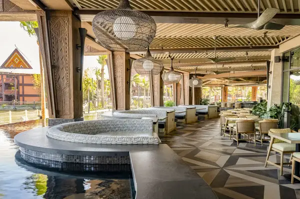 Outdoor seating area of a Polynesianthemed bar and grille near water with decor and furniture