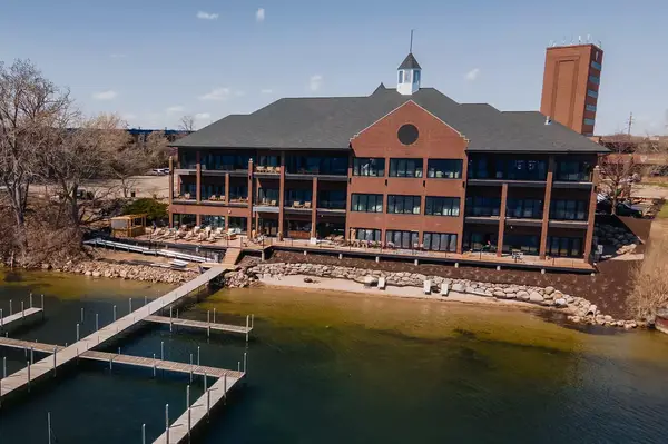 The exterior of a multi-story hotel building adjacent to a shoreline with docks and a waterfront area