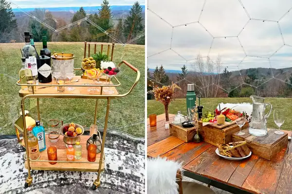 A drink cart and a rustic table with food and drinks outdoors near a forest inside a geodesic dome structure