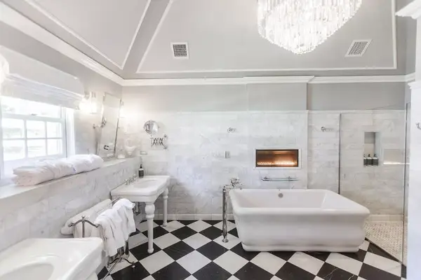 Luxury bathroom with a tub, sink, window, and chandelier