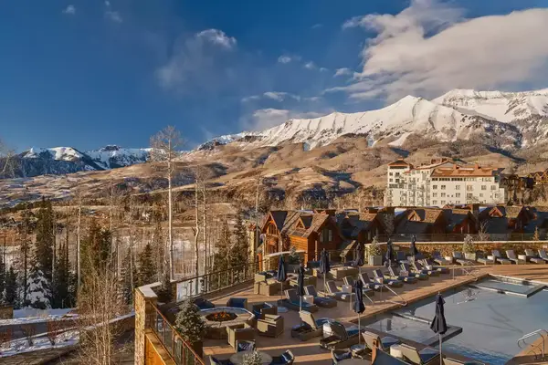 aerial views of outdoor wood resort next to snowy mountain in distance
