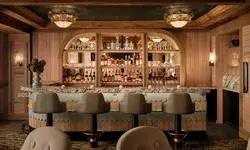 interior view of barstool with warmly lit mirror bar with many bottles