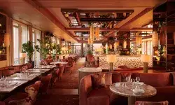 Elegant dining area with tables, chairs, and bar seating, showcasing refined design and ambiance