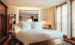 A bedroom with a bed, mirror, and large windows, modern design focus