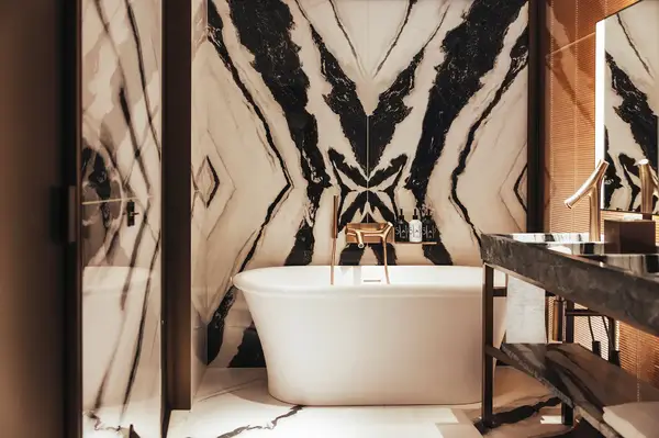 Bathroom featuring a freestanding bathtub and a decorative patterned wall