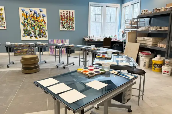 Art studio with tables set for painting and art supplies visible