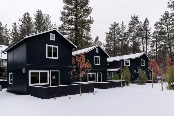 Exterior of black two story cabin homes in the snow at Noble + Proper at Big Bear Lake in California