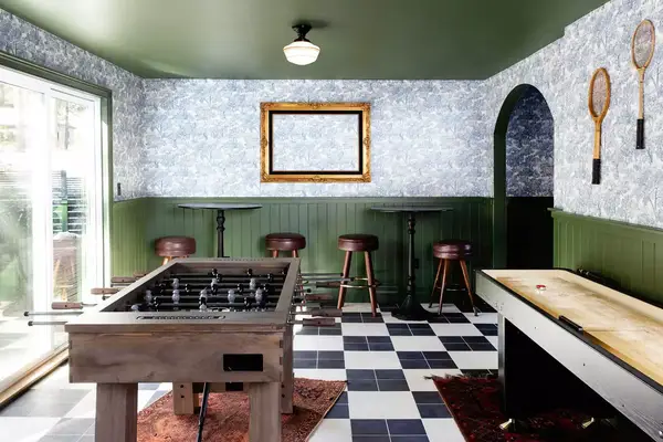 Interior game room with foosball and shuffleboard in a cabin at Noble + Proper at Big Bear Lake in California
