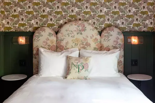 Bedroom with floral headboard and wall paper in a cabin at Noble + Proper at Big Bear Lake in California