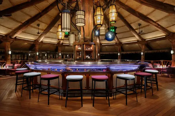 A dining and bar area with elegant lighting and wooden designs