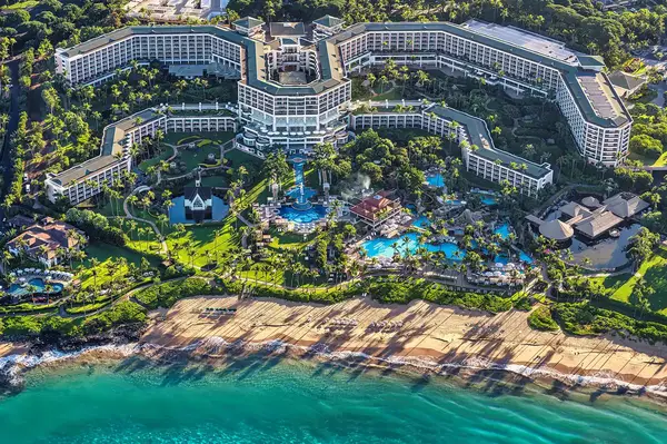 Aerial view of a beach resort with multiple pools and a beachfront