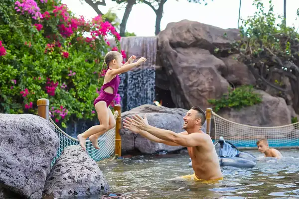 A father and daughter playing in the pool