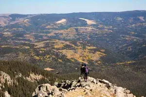 Two hikers at the summit of Santa Fe Baldy in the Sangre de Cristo Mountains of Santa Fe, New Mexico