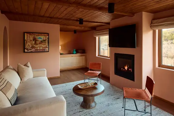Hotel guestroom with a seating area, fireplace, and large windows