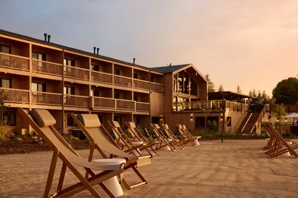 Hotel building with balconies and outdoor seating area with reclining chairs