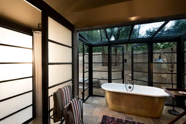 Luxurious bathroom with a standalone bathtub and large glass windows offering outdoor views