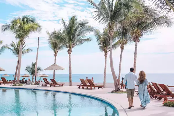 A couple walking around the pool 