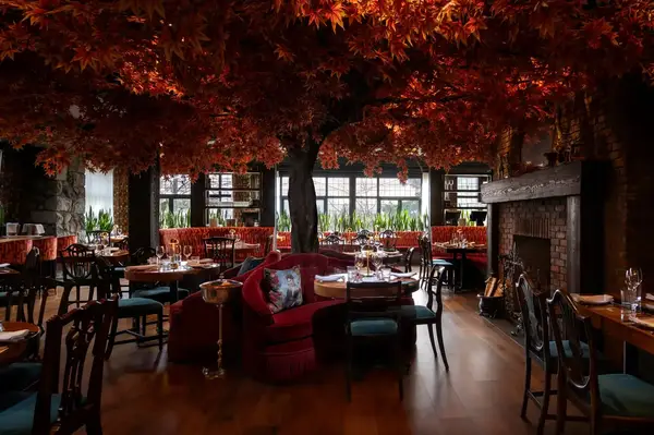 Well-decorated dining area with prominent tree-like ceiling centerpiece and elegant table settings