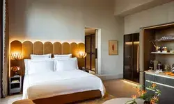 Luxury hotel bedroom with a stylish bed, modern furnishings, and decorative accents in a spacious setting