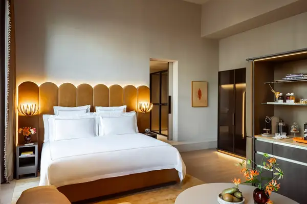 Luxury hotel bedroom with a stylish bed, modern furnishings, and decorative accents in a spacious setting